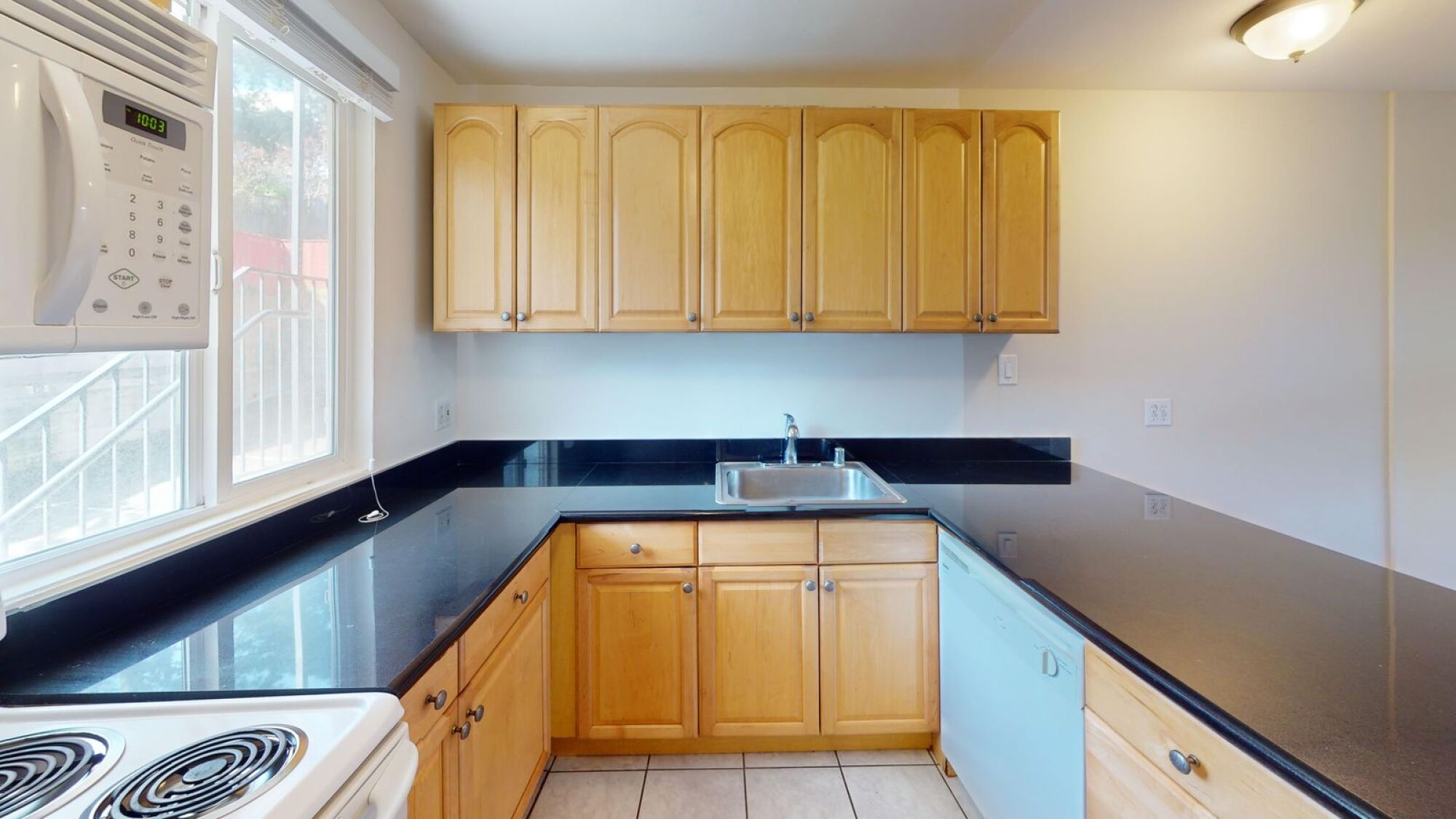 A kitchen with wooden cabinets and a black countertop.