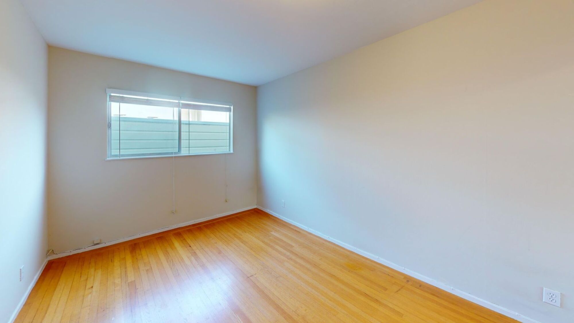A room with wooden floors and a window.