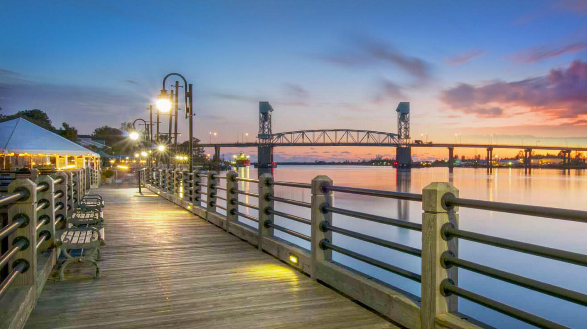 Sunset over the Wilmington Riverwalk and Cape Fear Memorial Bridge, near The Sterling at Center Point in Wilmington, NC.