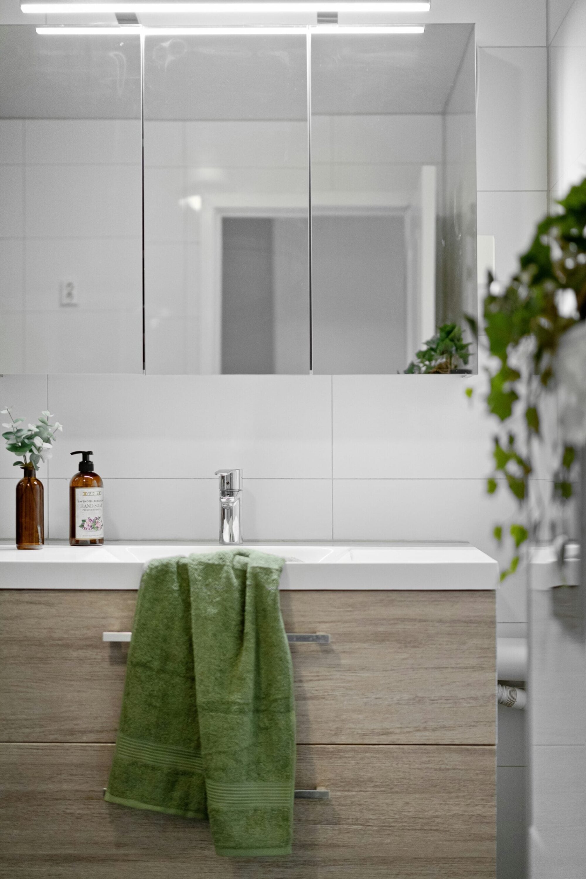 Sonder: A clean bathroom scene with a sink, mirror, and a vibrant green towel displayed prominently.