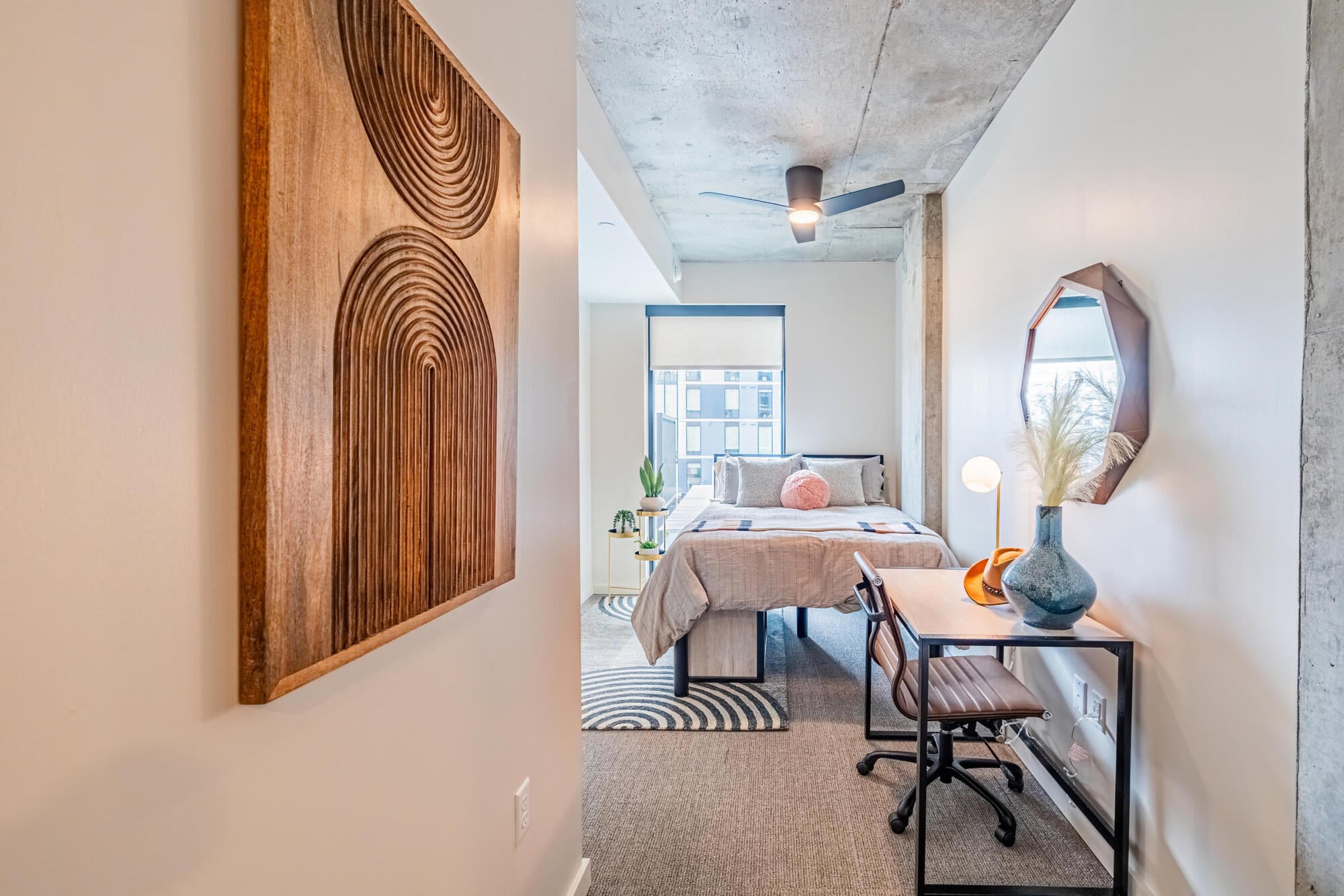 Bedroom with built-in study desk and designer furnishings at Rev in College Station, TX.