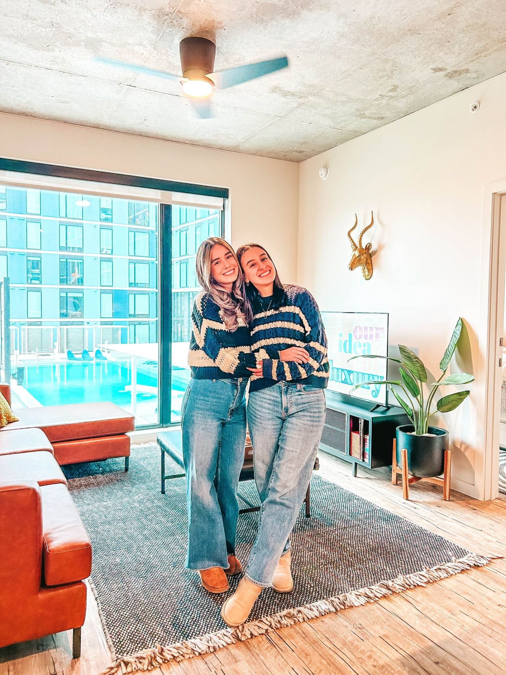 Roommates in a furnished living room overlooking the pool at Rev in College Station, TX.