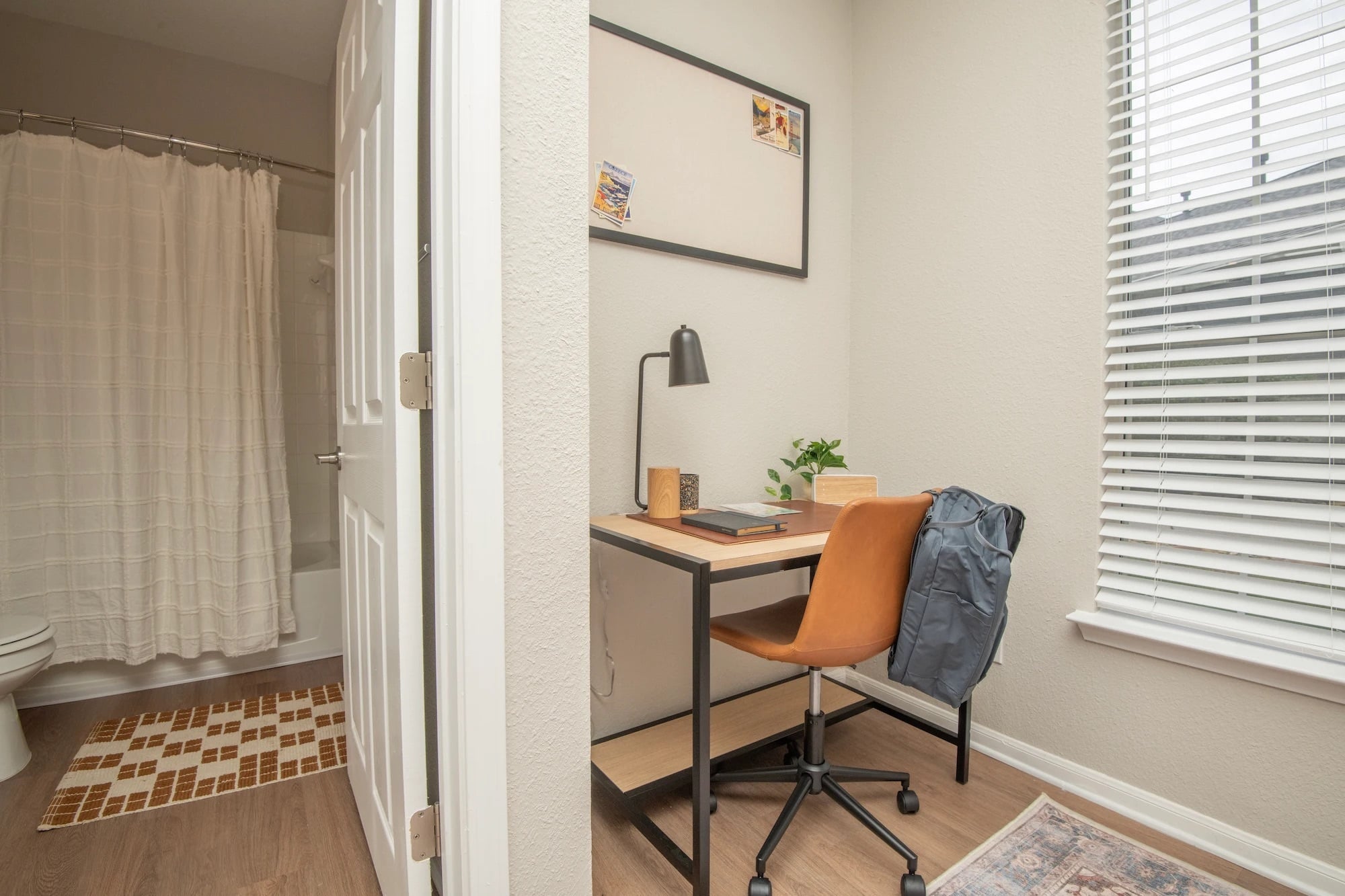 Bedroom study nook at The Heights with a desk, chair, window, and adjoining bathroom.