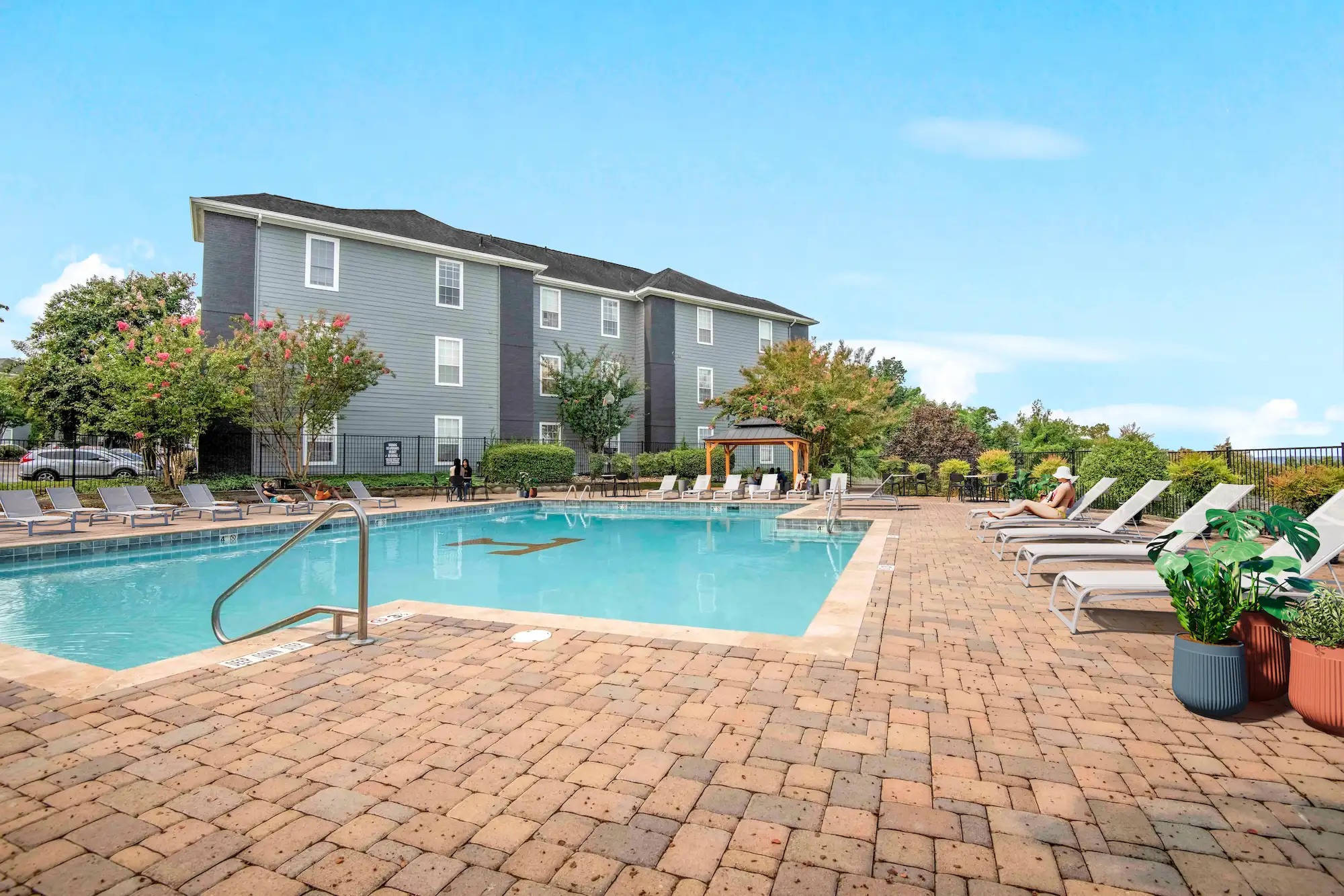 Resort-style swimming pool at The Heights with lounge chairs and apartment buildings.