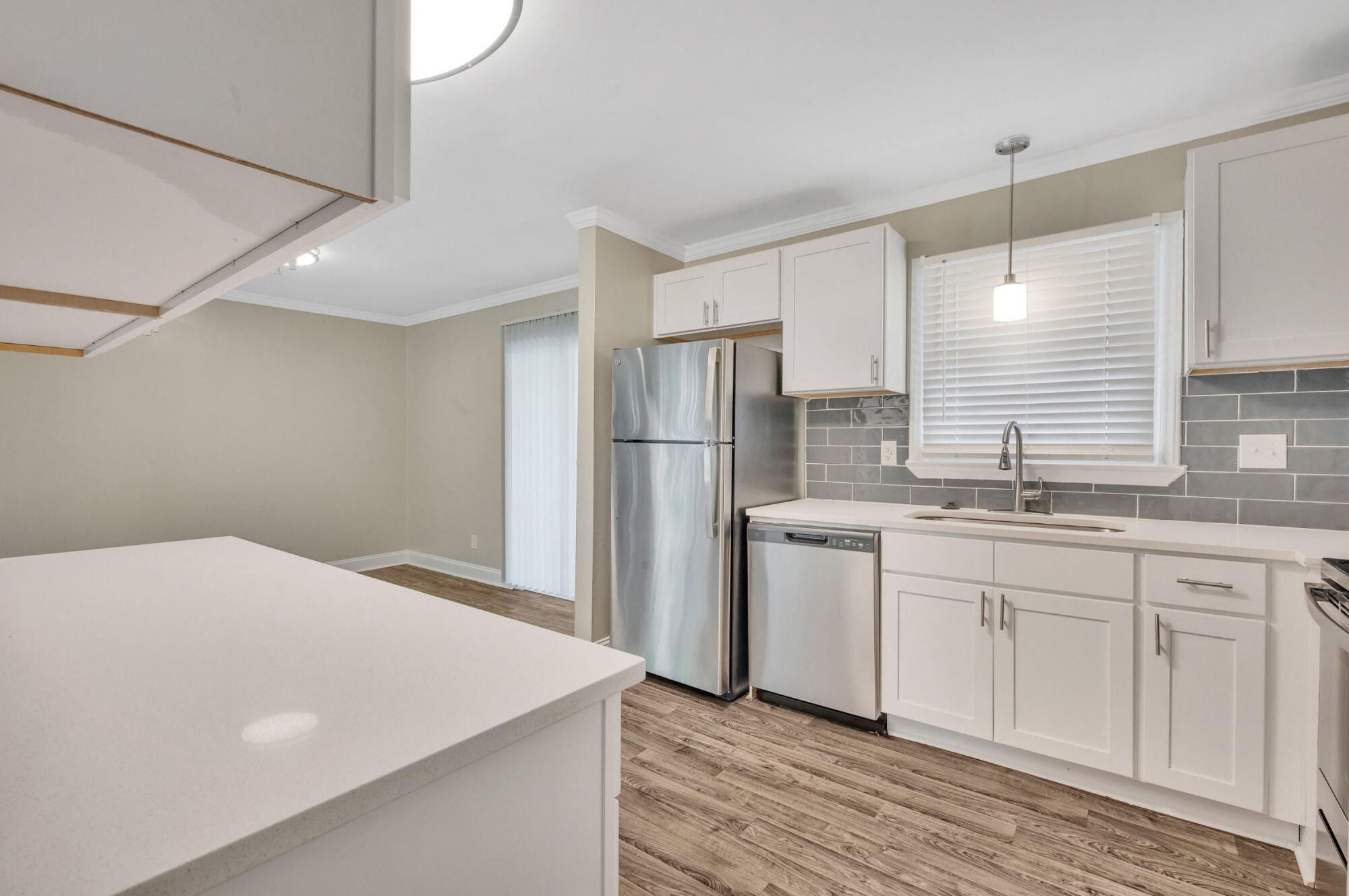 Kitchen at Maple Run in Charlotte, NC with a quartz-topped island, stainless steel appliances, and white shaker cabinetry.