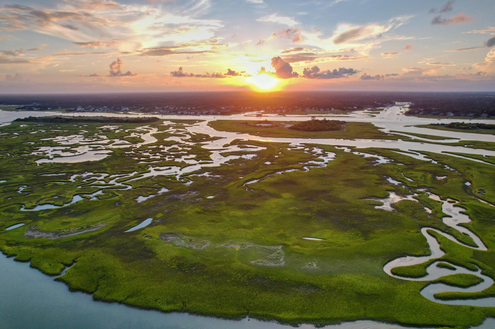 Sunset over the coastal salt marshes and tidal creeks near The Sterling at Center Point in Wilmington, NC, capturing the area's natural coastal beauty.