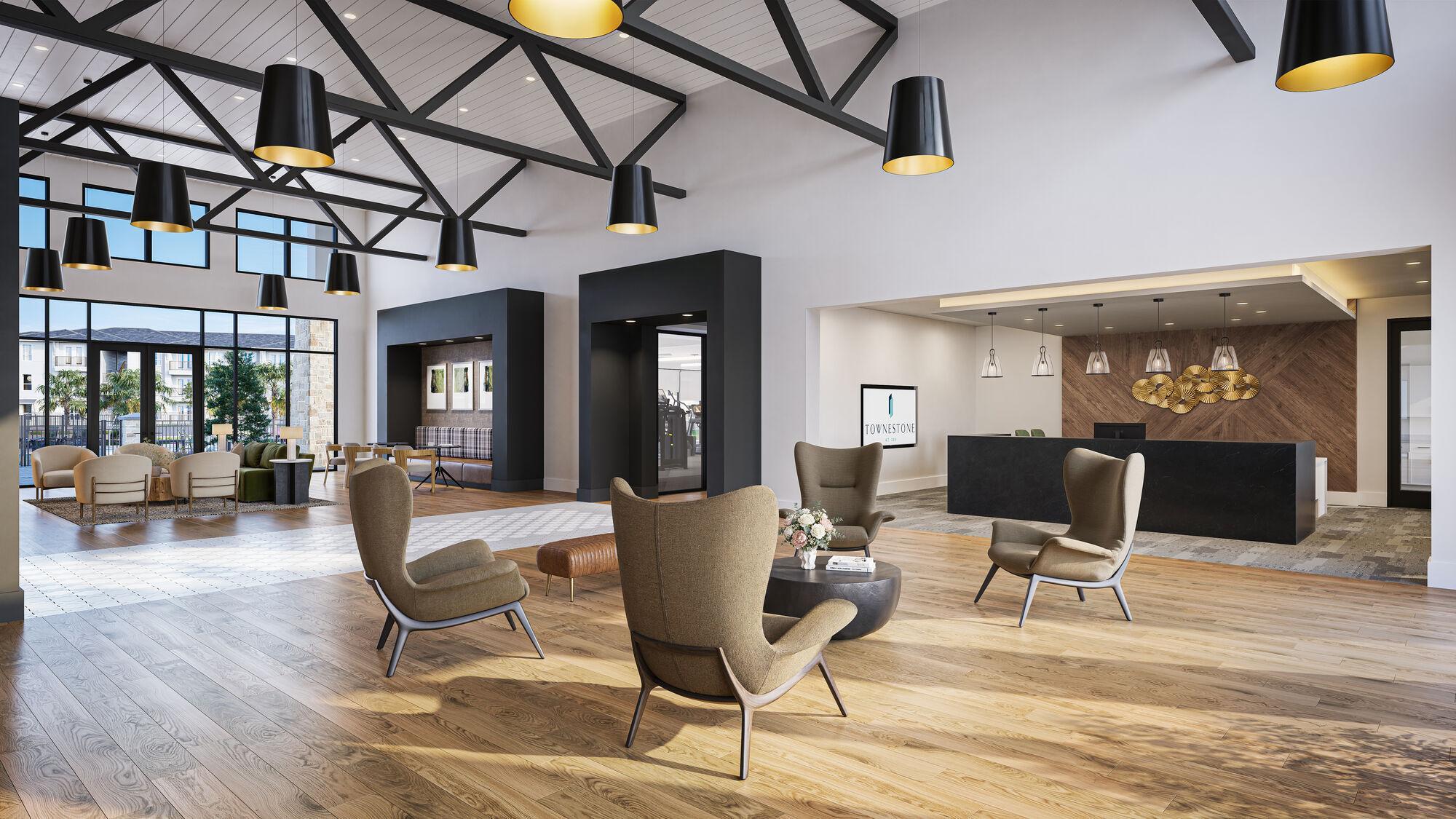 Modern lobby with high ceilings, wood floors, lounge chairs, a reception desk, and large windows letting in natural light.