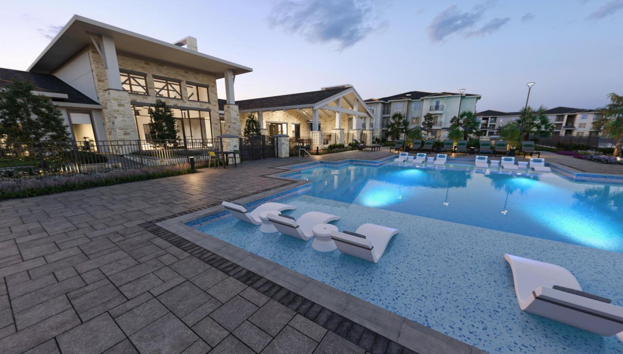 Modern apartment complex with a large outdoor pool, lounge chairs in the water, and landscaped surroundings at dusk.