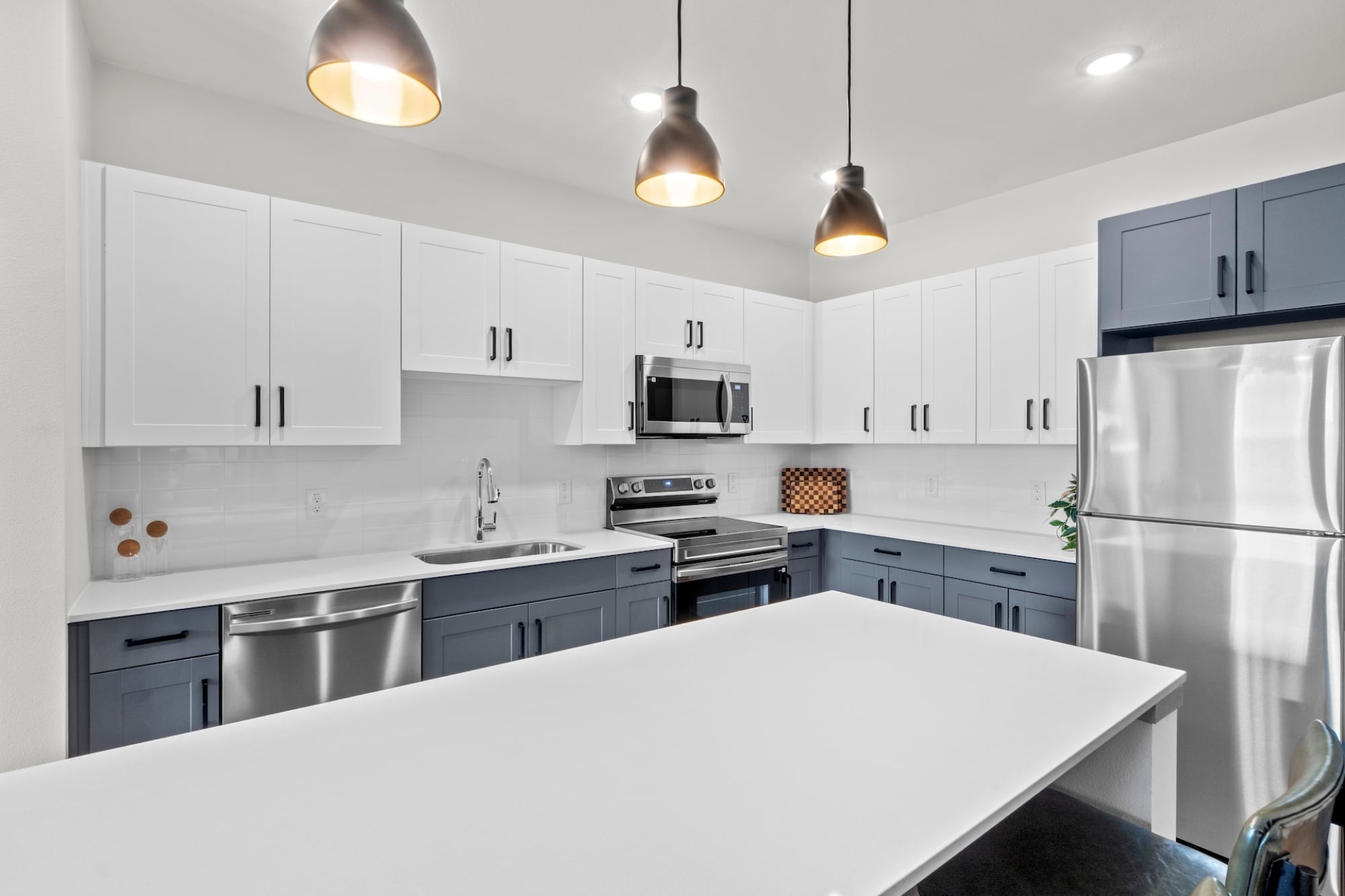 Modern Apartment Kitchen with stainless steel appliances, two-toned cabinetry, and quartz countertops in Austin TX