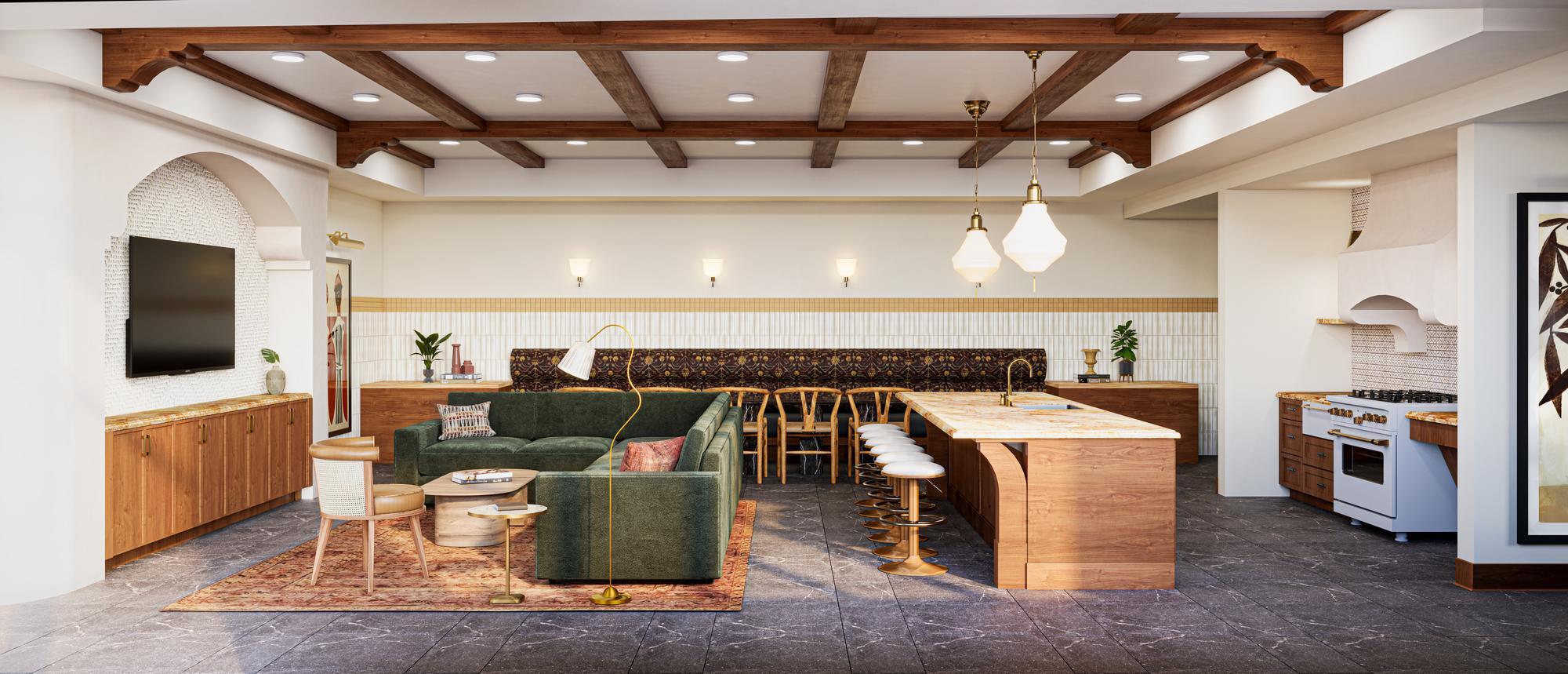 Modern kitchen and living area with wood accents, green sofa, island seating, and exposed ceiling beams.