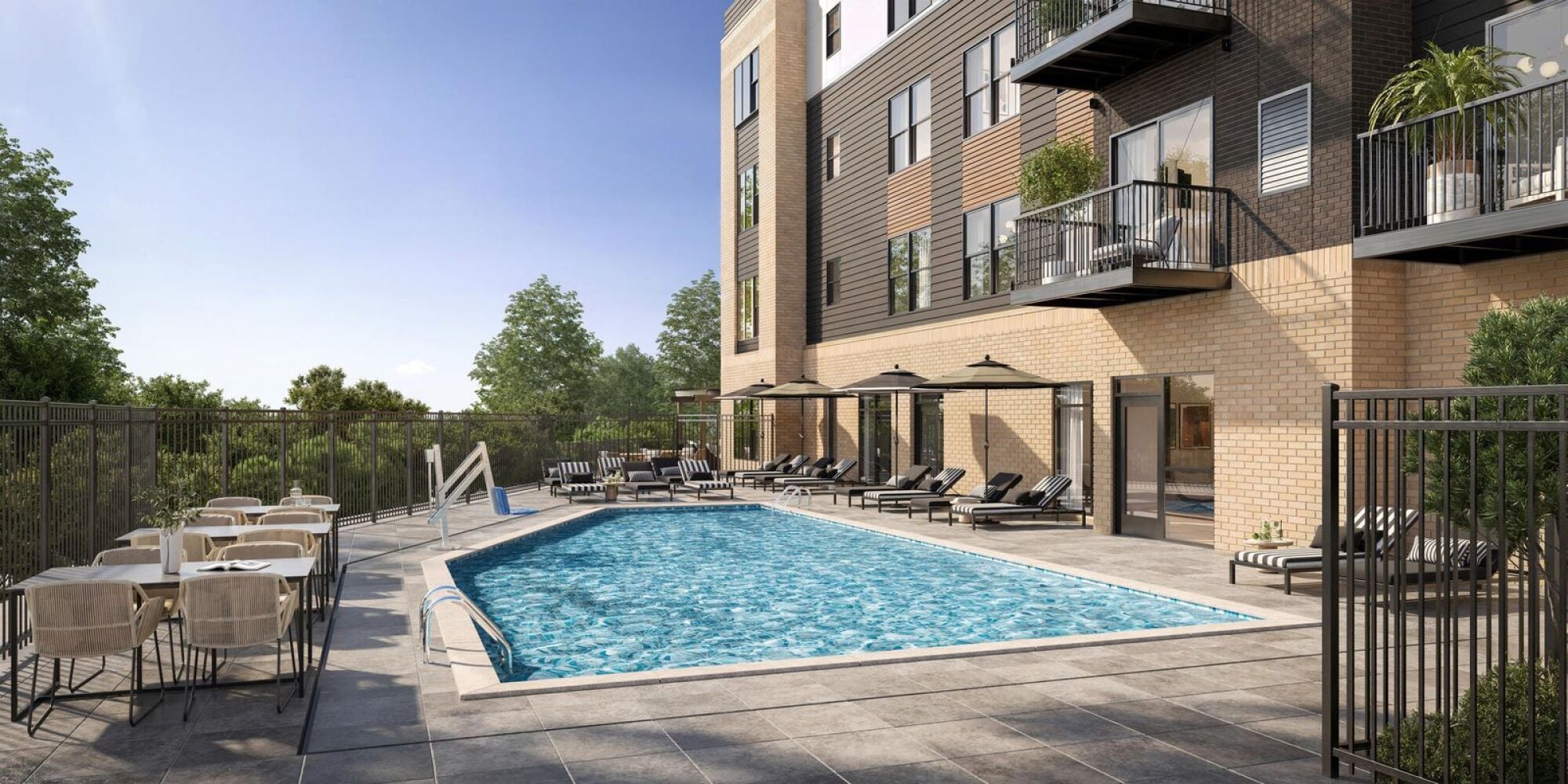 Outdoor pool area with lounge chairs, tables, umbrellas, and a modern apartment building in the background.