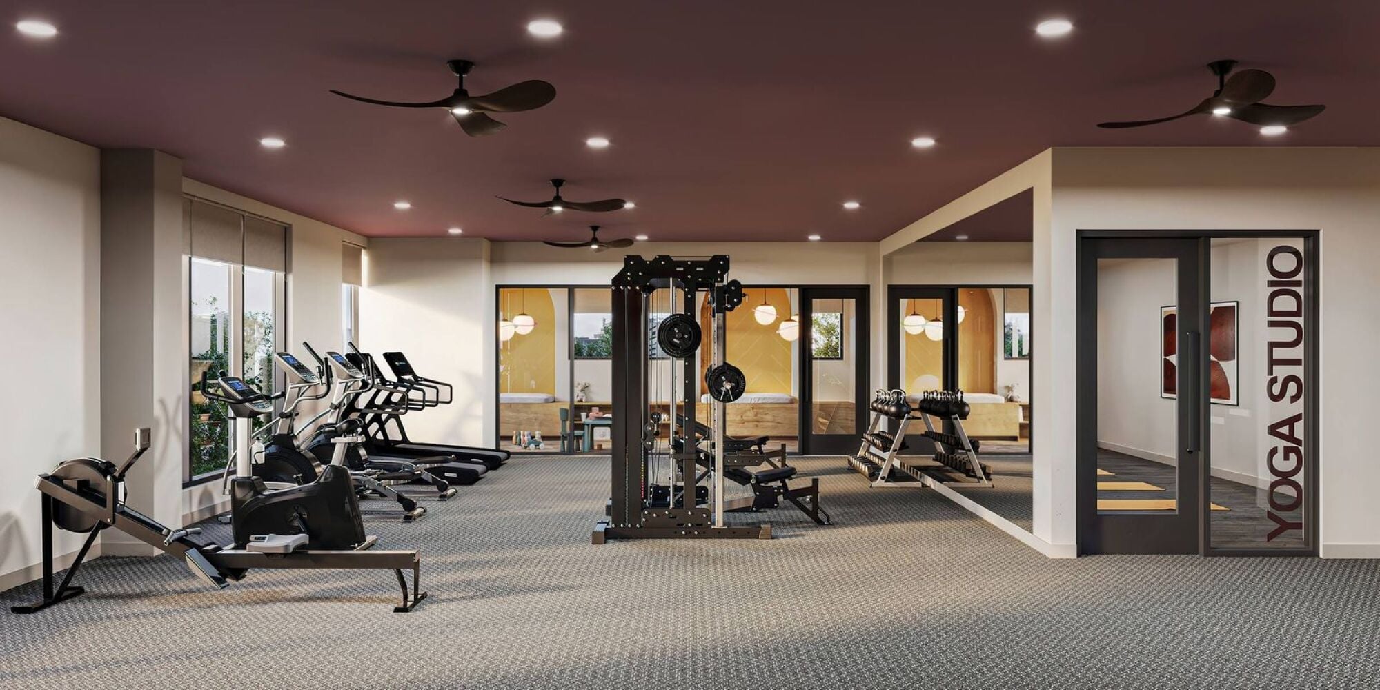 Modern gym with cardio machines, weight equipment, and a glass-enclosed yoga studio on the right at Harlow.