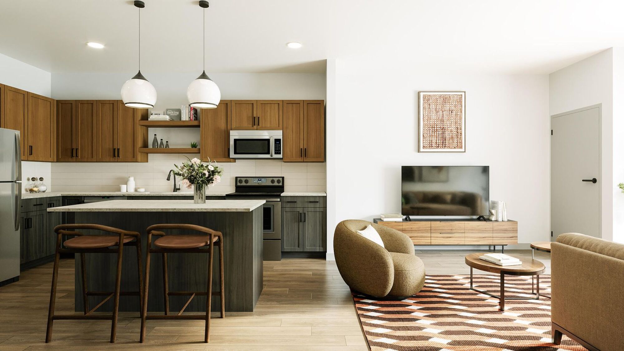 Modern kitchen and living room with wood cabinets, island seating, TV, and cozy chairs on a patterned rug.