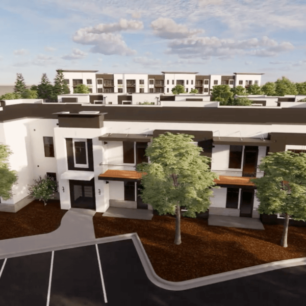 A modern apartment complex with a parking lot in front.