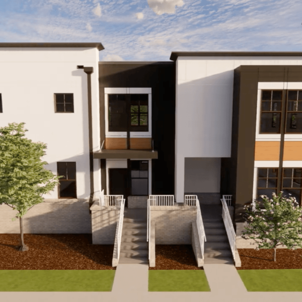 A modern two-story building with white walls and brown trim.