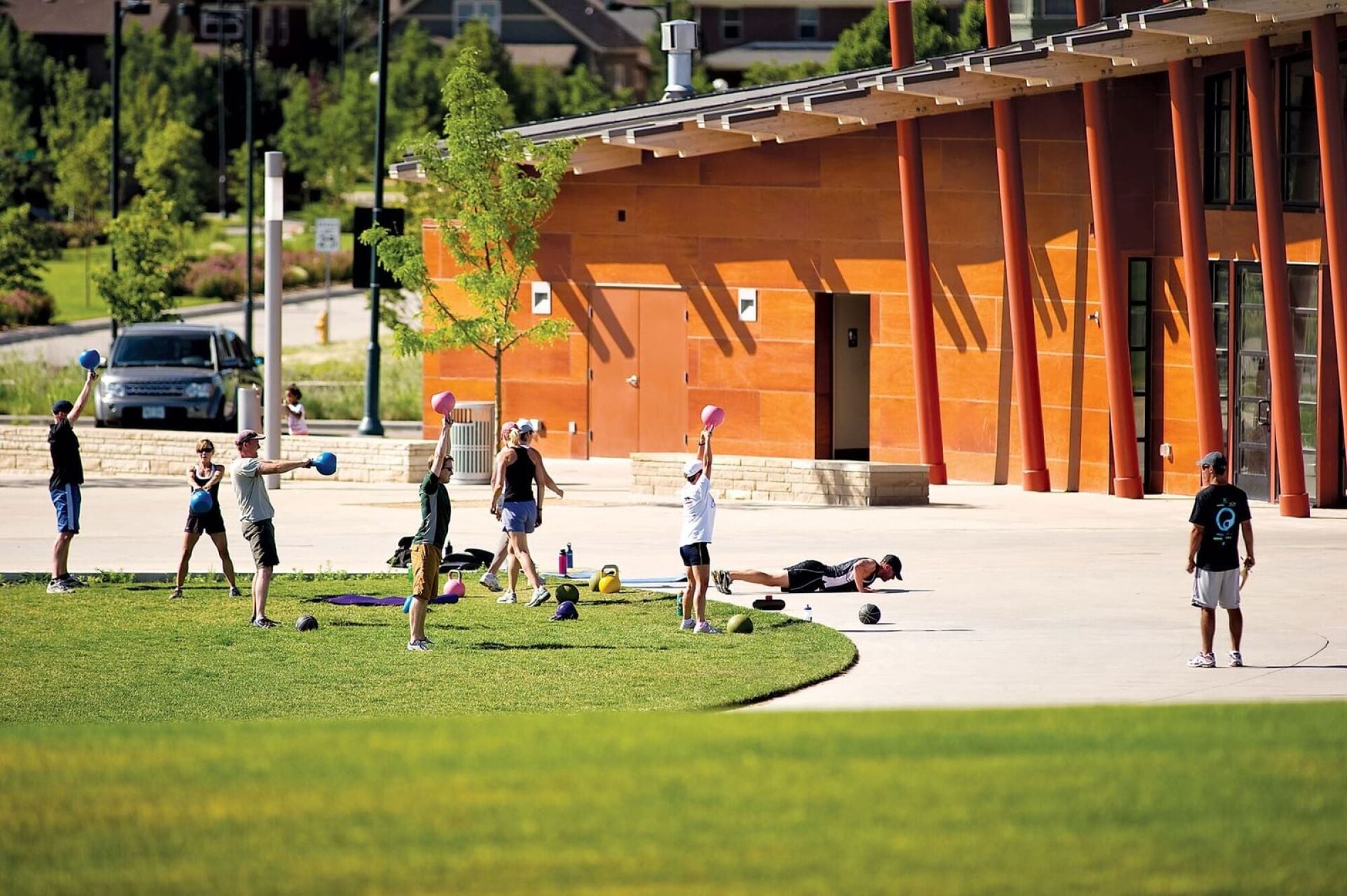 Outdoor fitness class with people swinging kettlebells