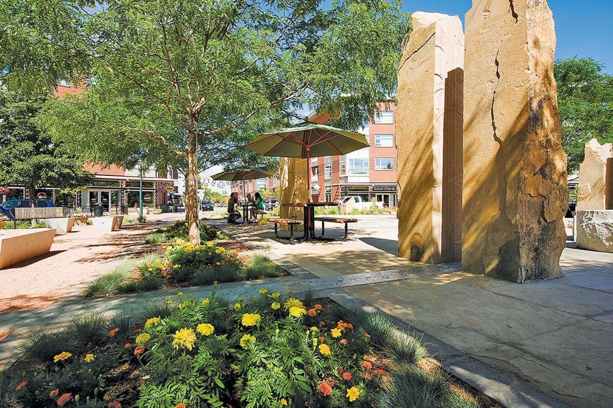 Beautiful outdoor seating area in public plaza with flowers and rock sculptures