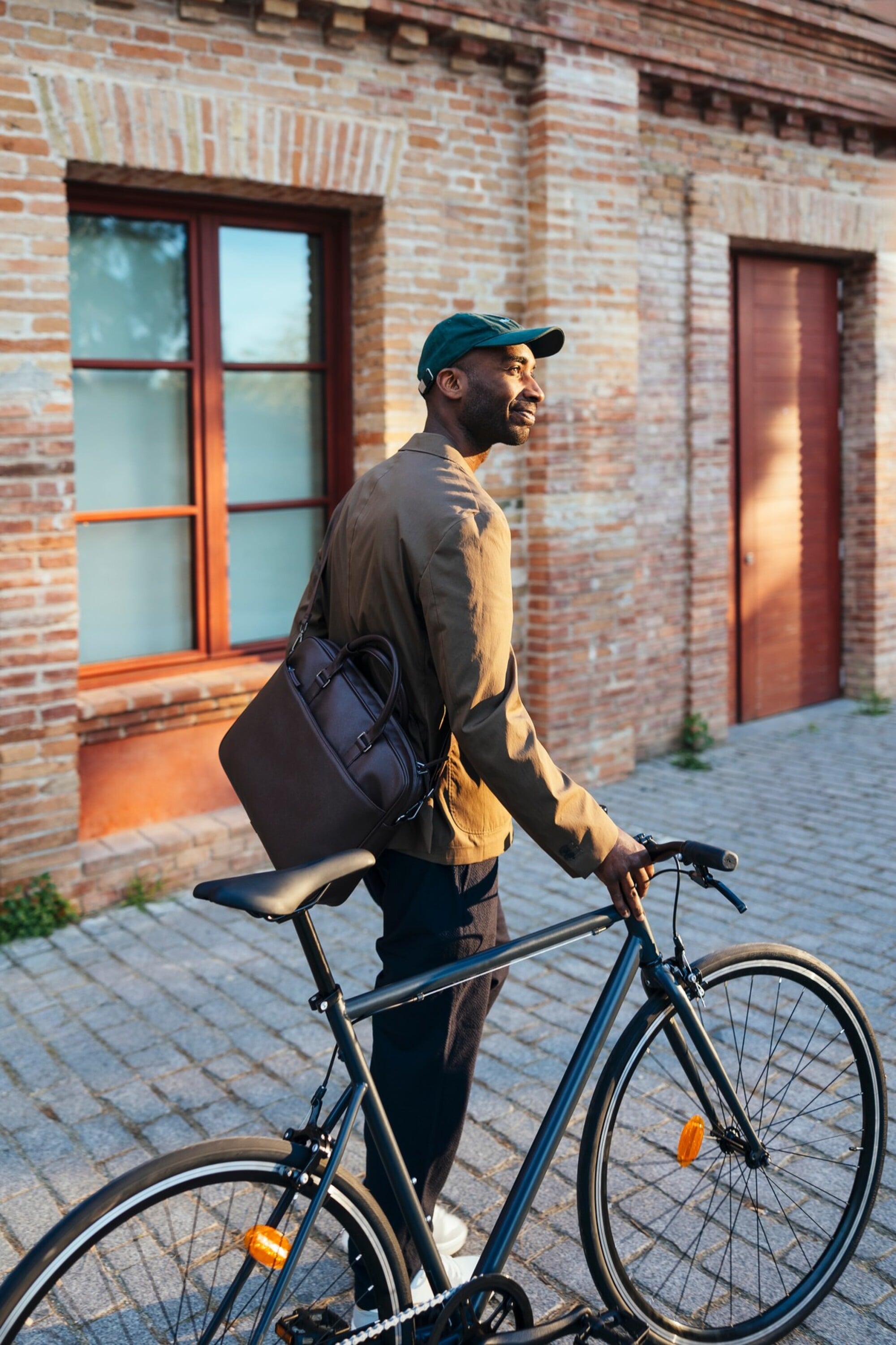 The Wade A man wearing a backpack stands next to a bicycle, ready for an outdoor adventure.