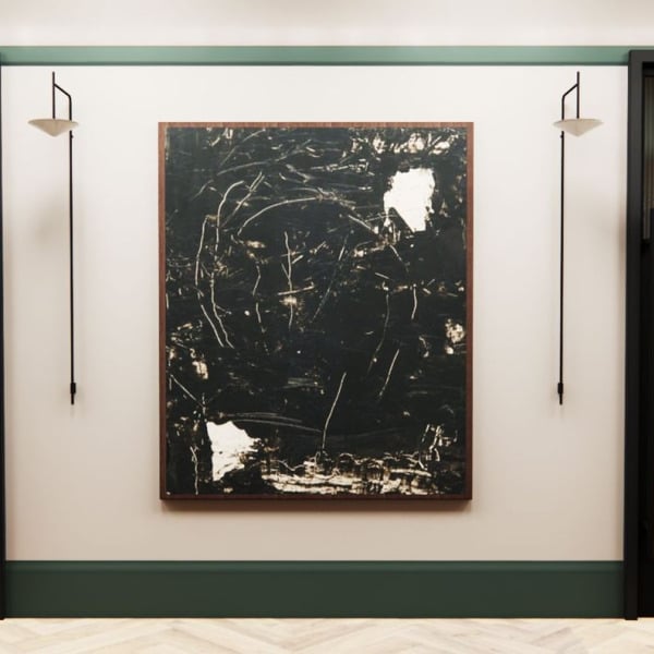 A black and white painting hangs on a wall above a black door.