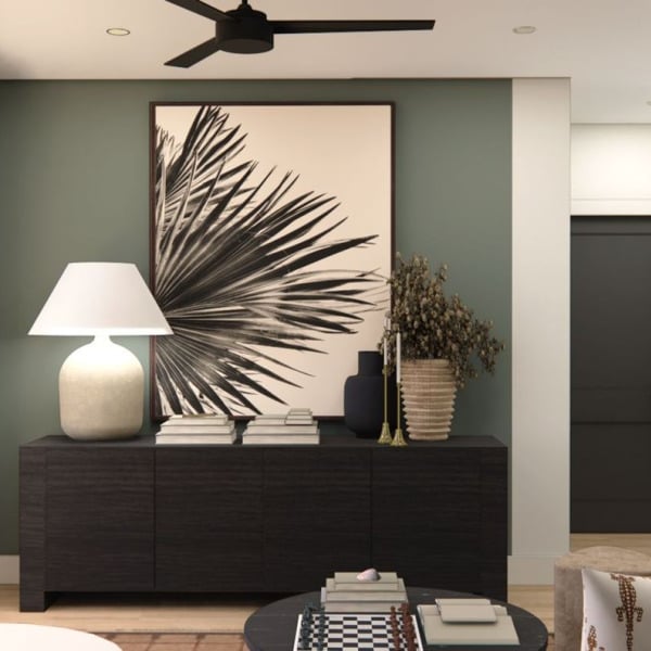 A living room with a black couch, a white coffee table, and a large mirror on the wall.