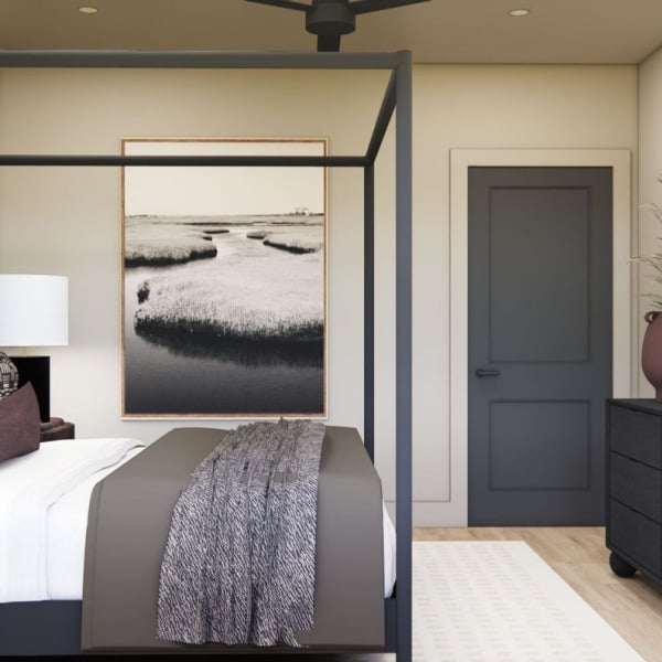 A bedroom with a large bed and a painting on the wall.