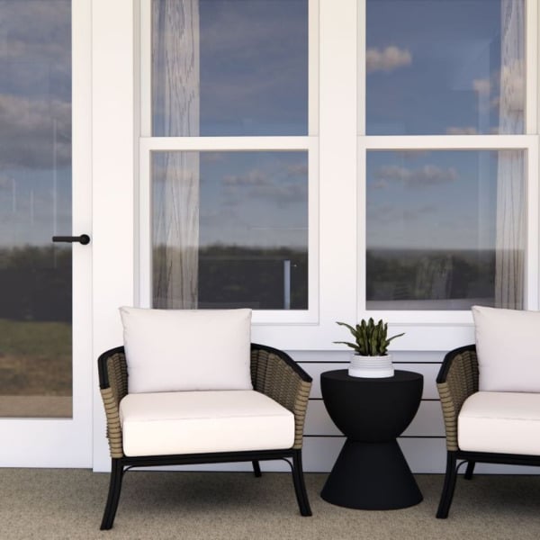 A white chair with a black table in front of a window.