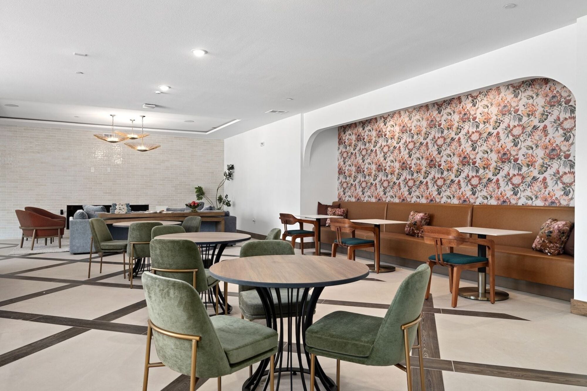 Wixby House clubroom in Austin, TX featuring a spacious kitchen, marble island, dining tables, lounge seating, and floral accent wallpaper.