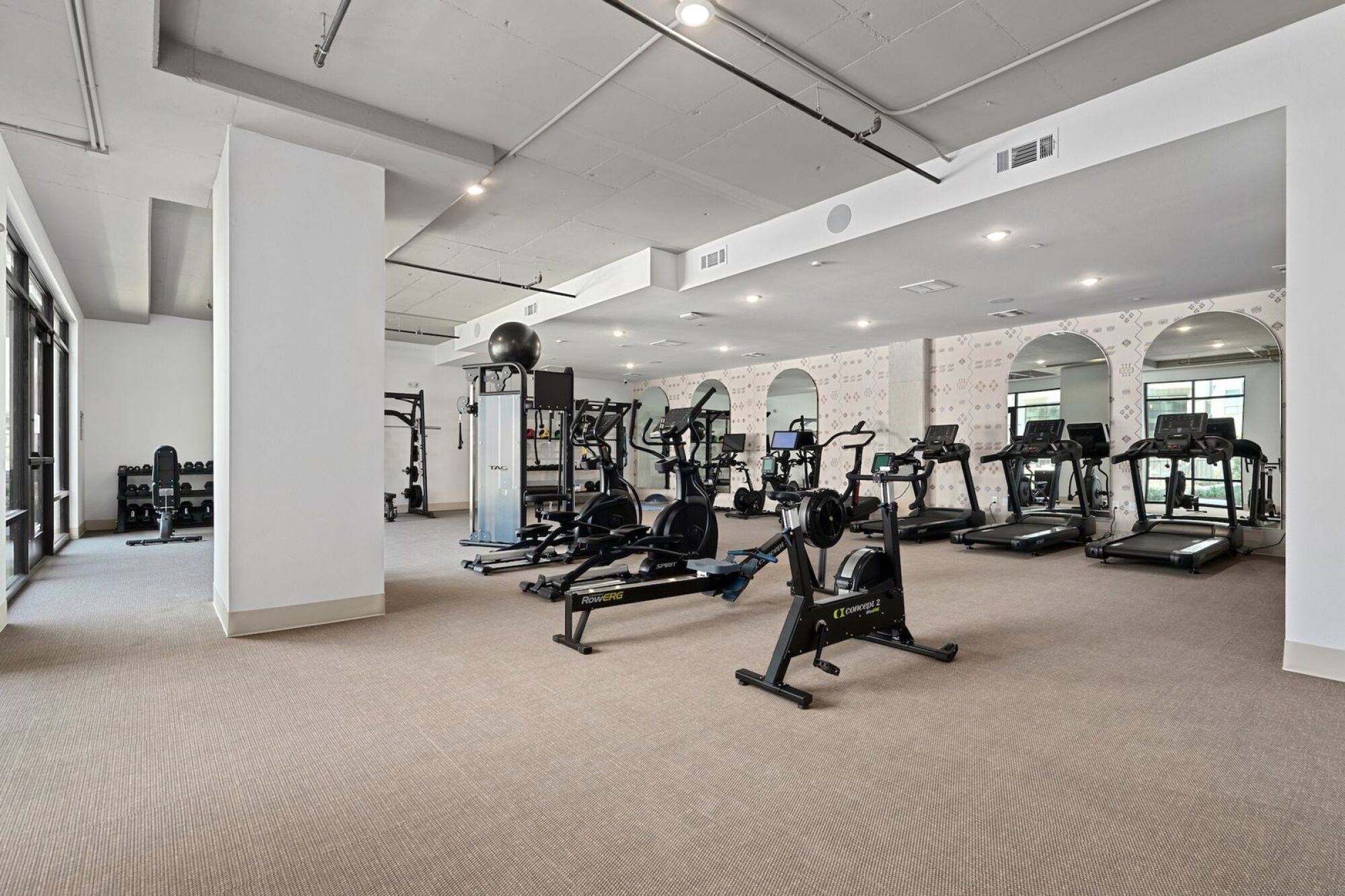 Wixby House fitness center in Austin, TX featuring treadmills, rowing machines, strength training equipment, and free weights.