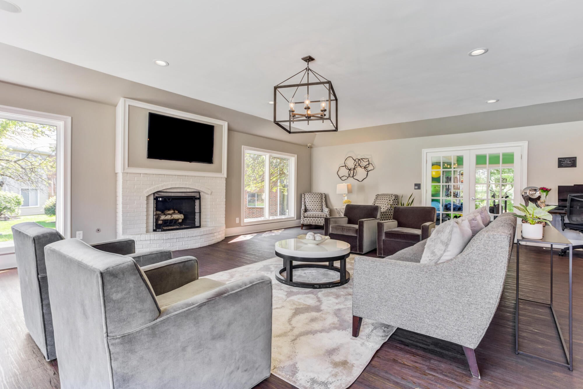 Clubhouse lounge with white brick fireplace and TV at Ashford at Geneva apartments in Geneva, IL