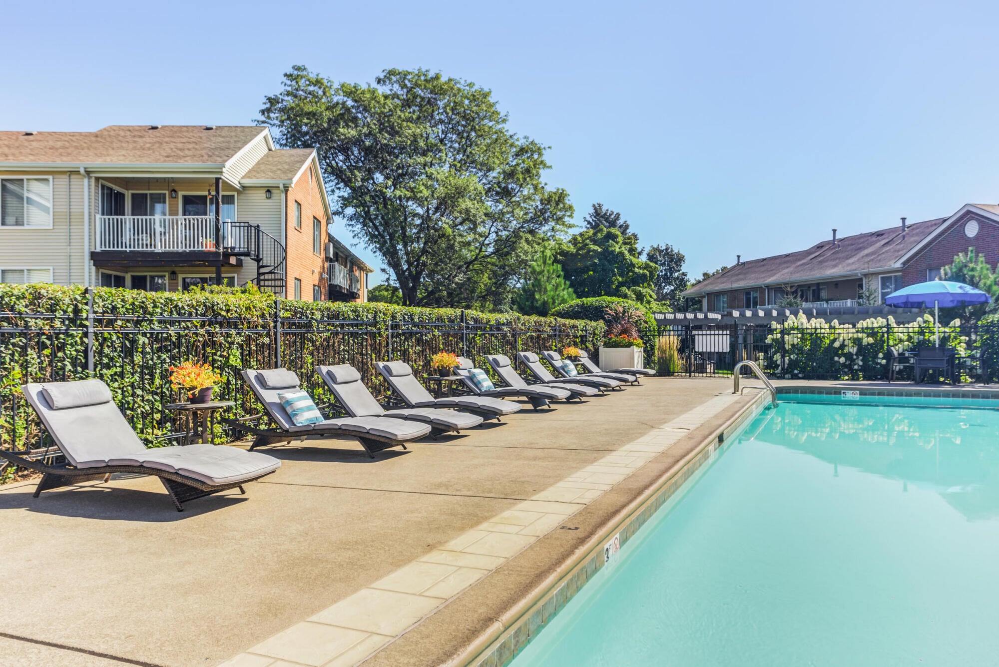 Outdoor swimming pool with lounge chairs and sundeck at Ashford at Geneva apartments in Geneva, IL