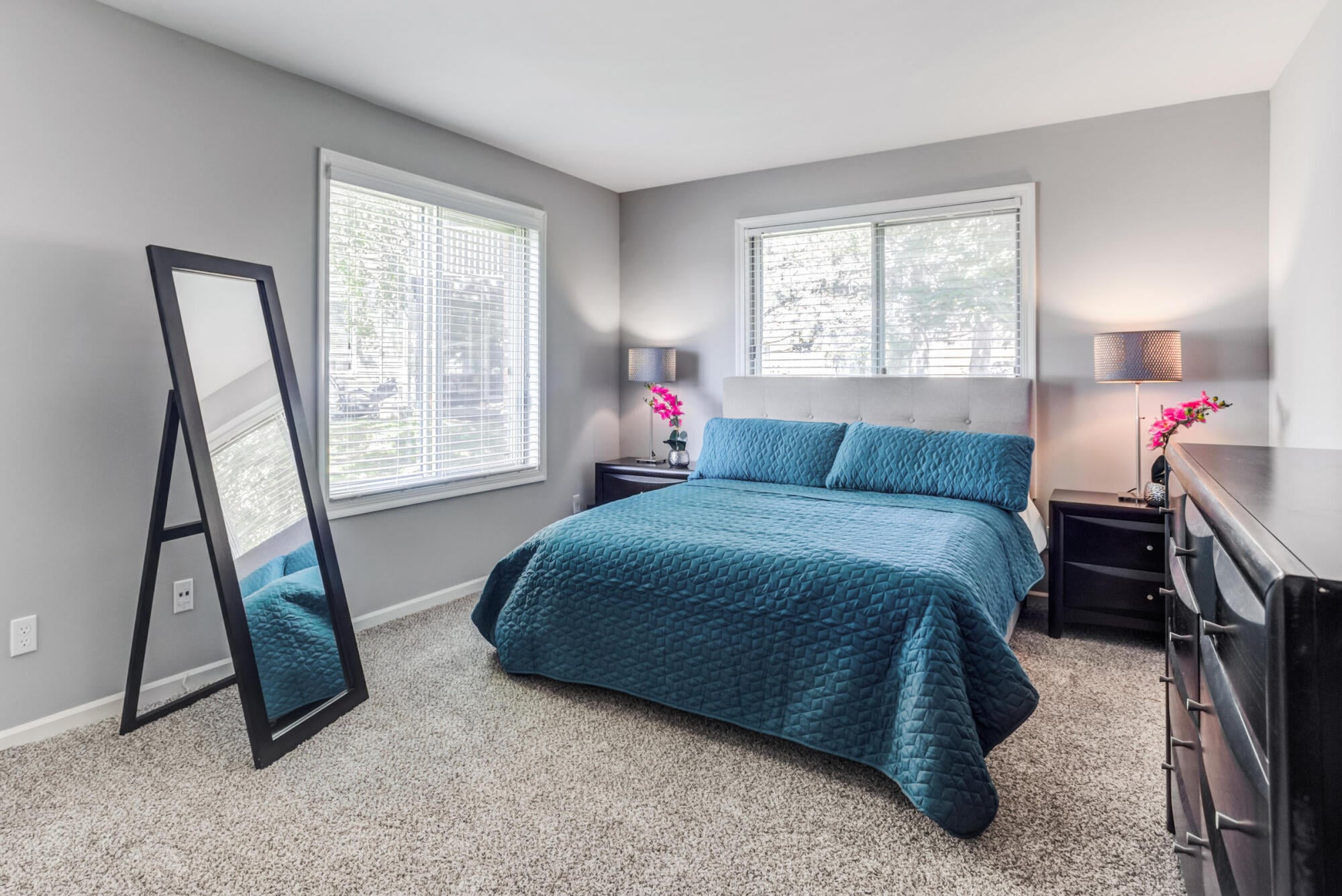 Spacious carpeted primary bedroom with dual windows at Ashford at Geneva apartments in Geneva, IL