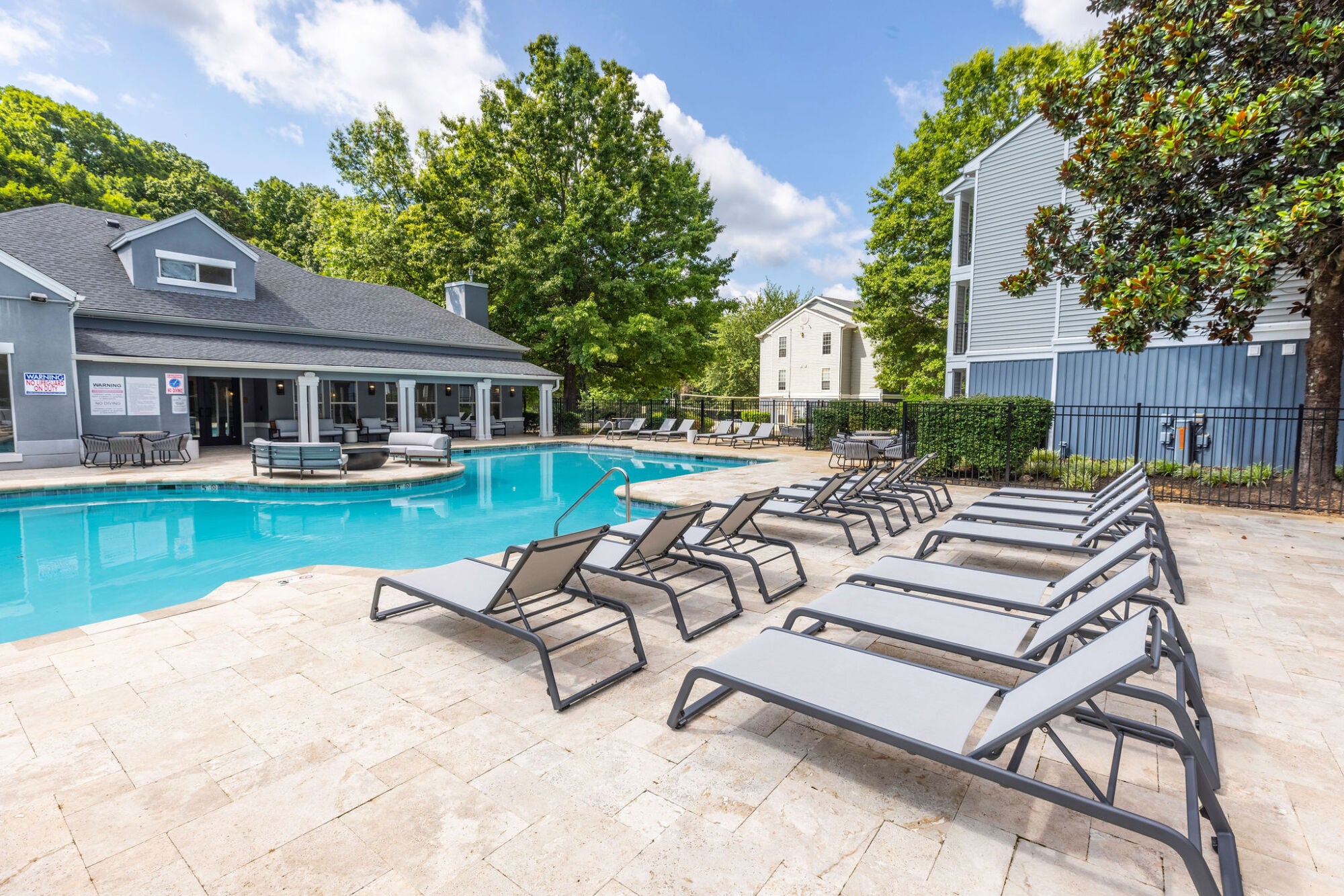 Swimming pool with clubhouse and sundeck seating at Knox Row apartments in Knoxville, Tennessee.