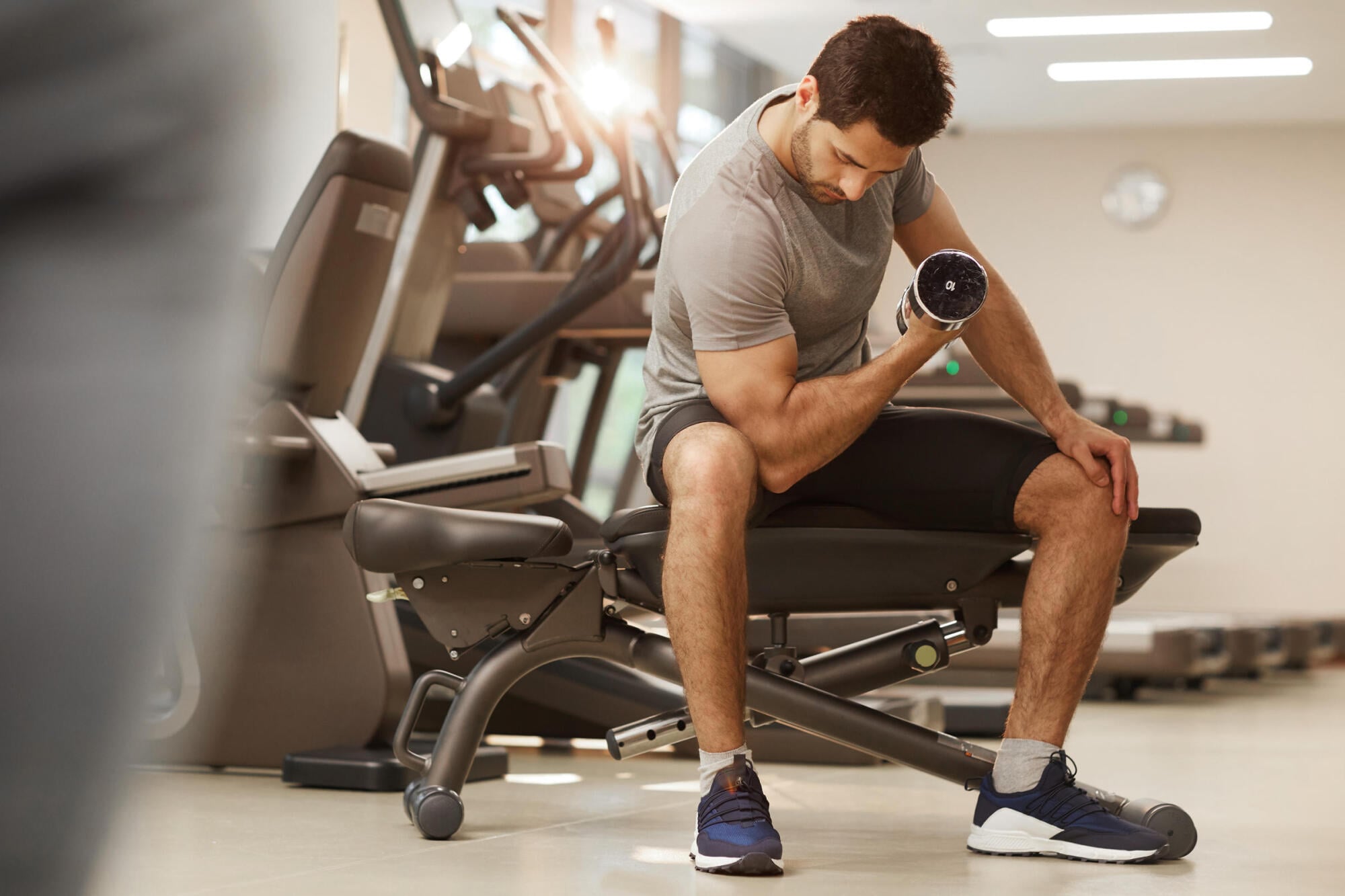 Resident using free weights in the on-site fitness room at Merit 38 apartments in Fargo, ND
