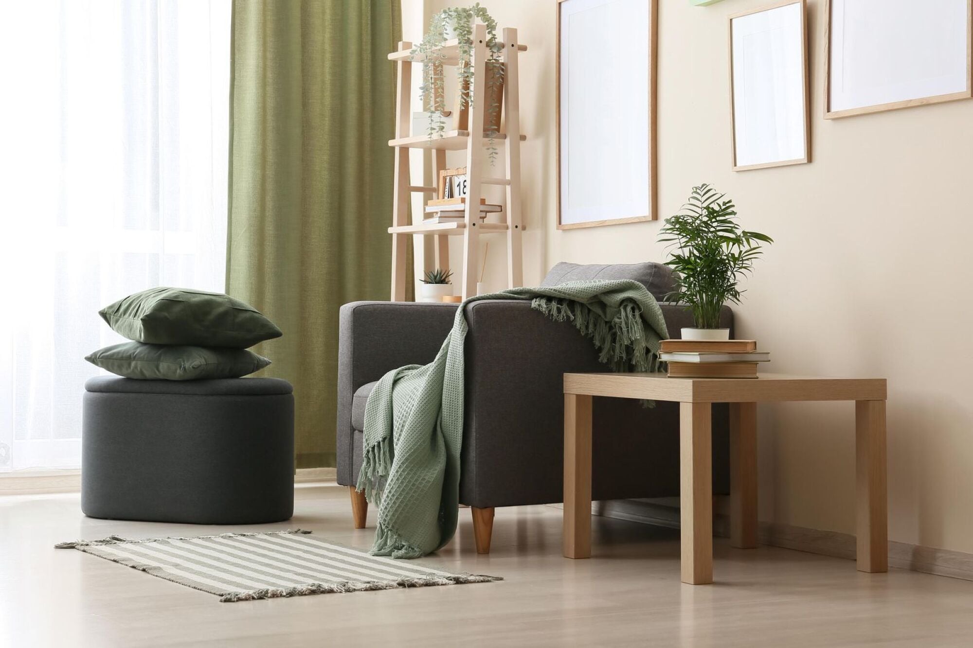 Apartment reading nook with green drapery, an armchair and an upholstered ottoman at Merit 38