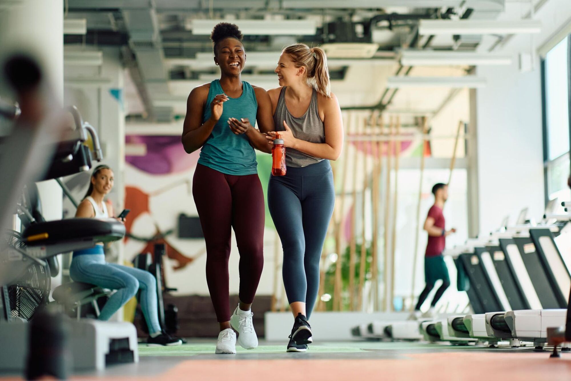 Two residents walking through the on-site fitness room at Merit 38 apartments in Fargo, ND
