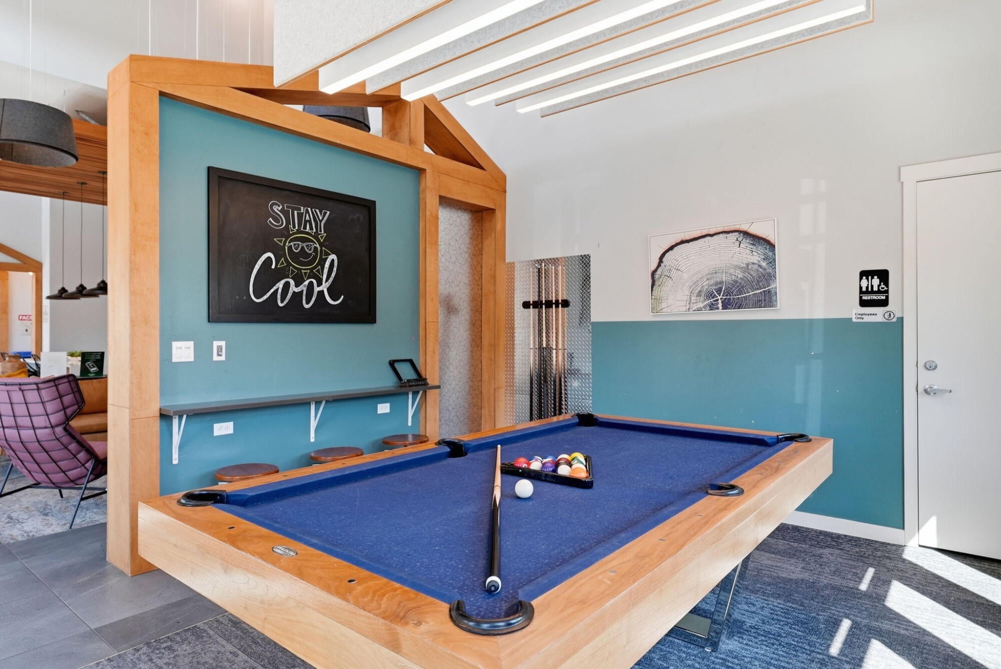 Blue-felt billiards table with a cue rack and chalkboard nook at Cypress in Redmond, Oregon.
