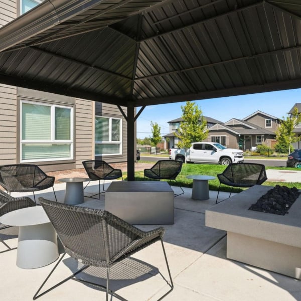 Covered outdoor pavilion with a gas fire table and lounge seating at Cypress in Redmond, Oregon.