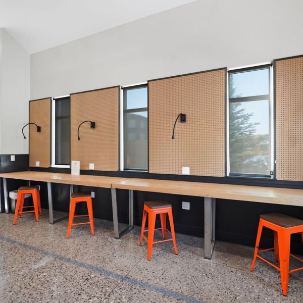 Resident work stations with pegboard task lighting and butcher-block counters at Cypress in Redmond, Oregon.