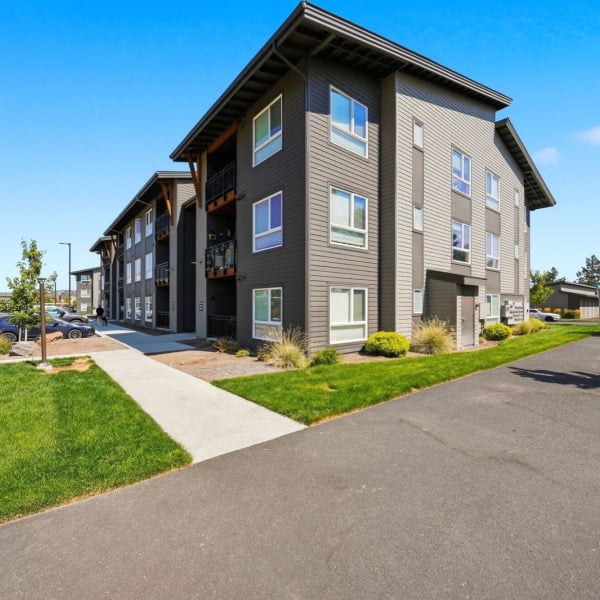 Open lawn and mature landscaping along the apartment buildings at Cypress in southwest Redmond, Oregon.