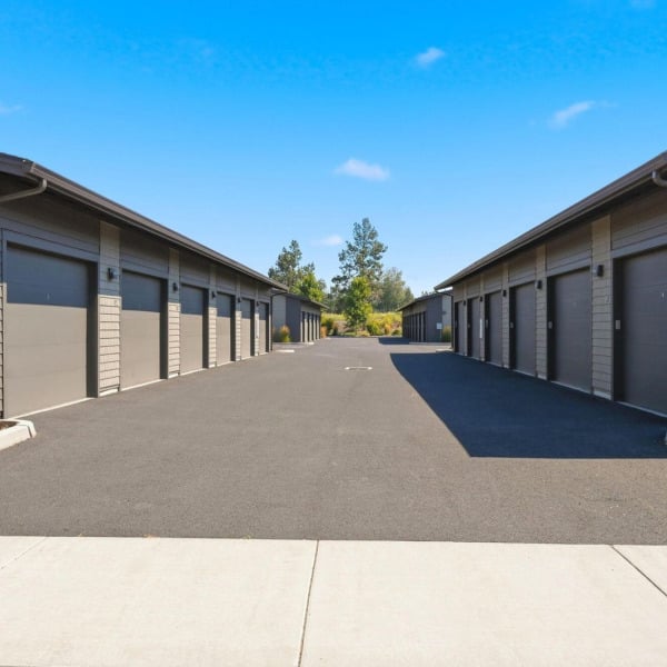 Rentable private garages lining the interior drive at Cypress apartments in Redmond, Oregon.