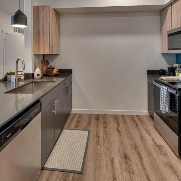 Furnished model kitchen with wood cabinetry and stainless appliances at Cypress in Redmond, Oregon.