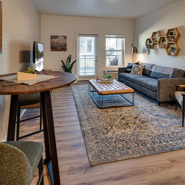 Styled model living area with layered rugs and modern shelving at Cypress in Redmond, Oregon.