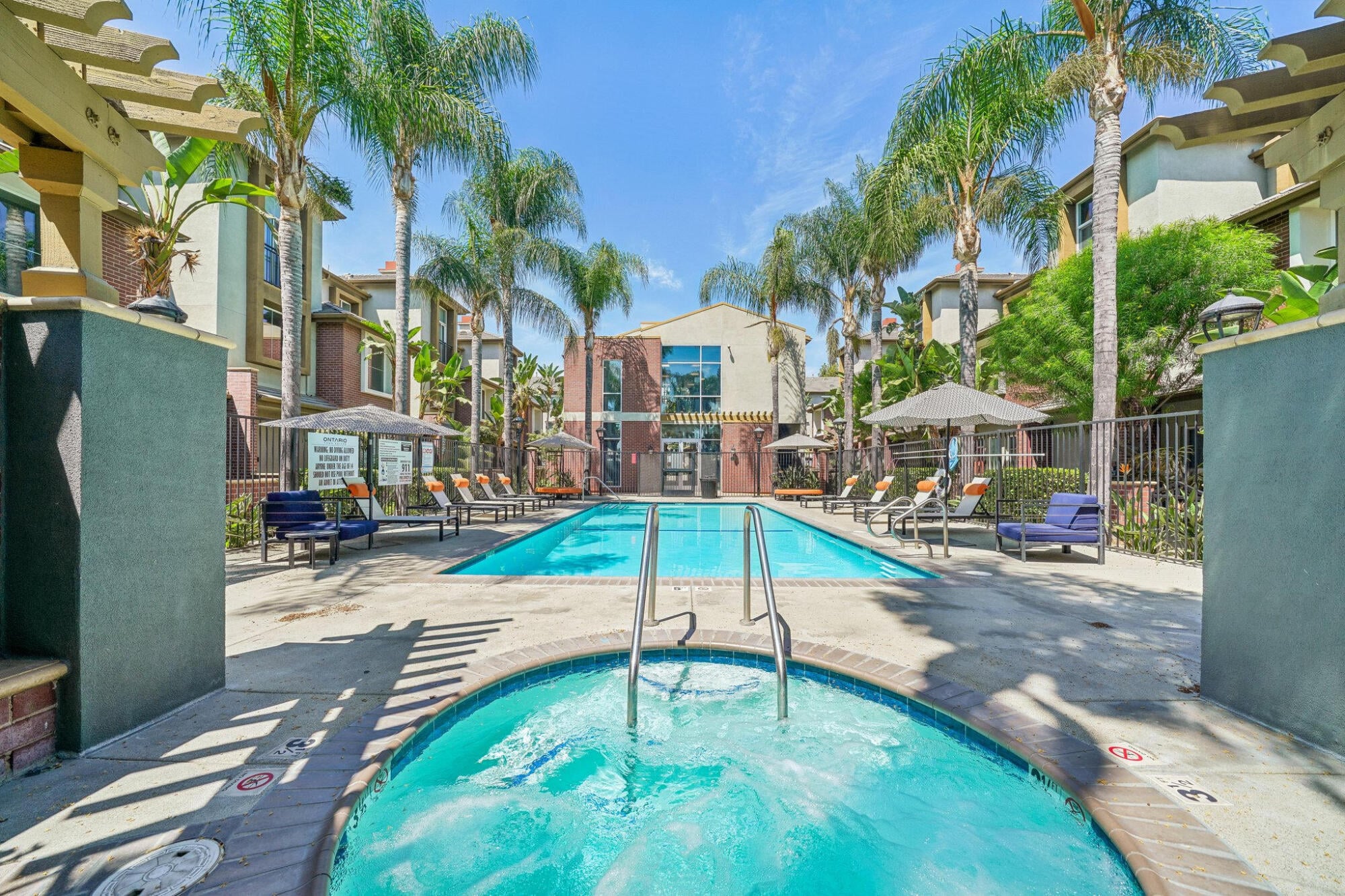 Spa and swimming pool at Ontario Town Square Townhomes in Ontario, CA, with the townhome buildings rising behind.
