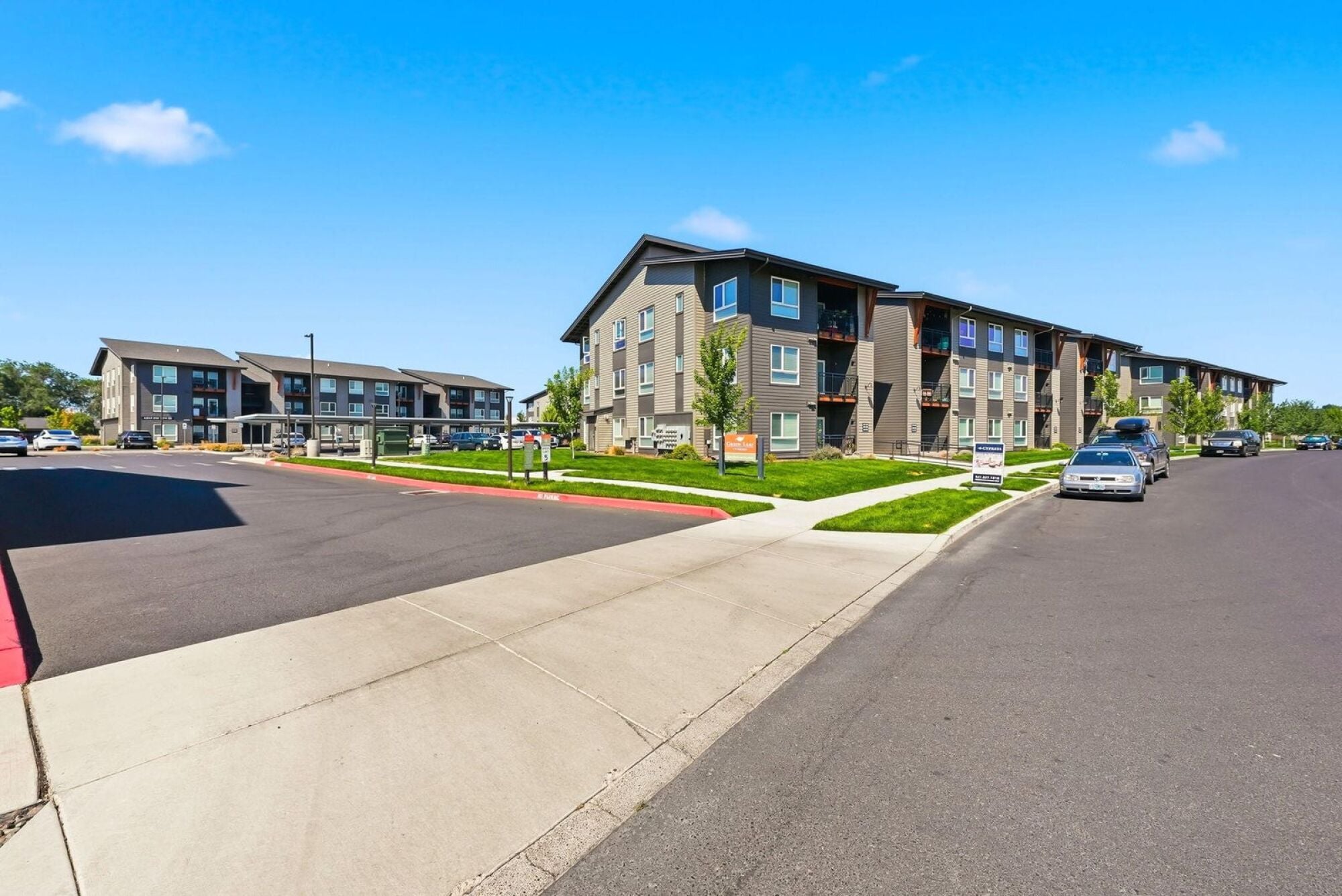 Corner view of the Cypress apartment community in southwest Redmond, Oregon, with monument signage and parking.