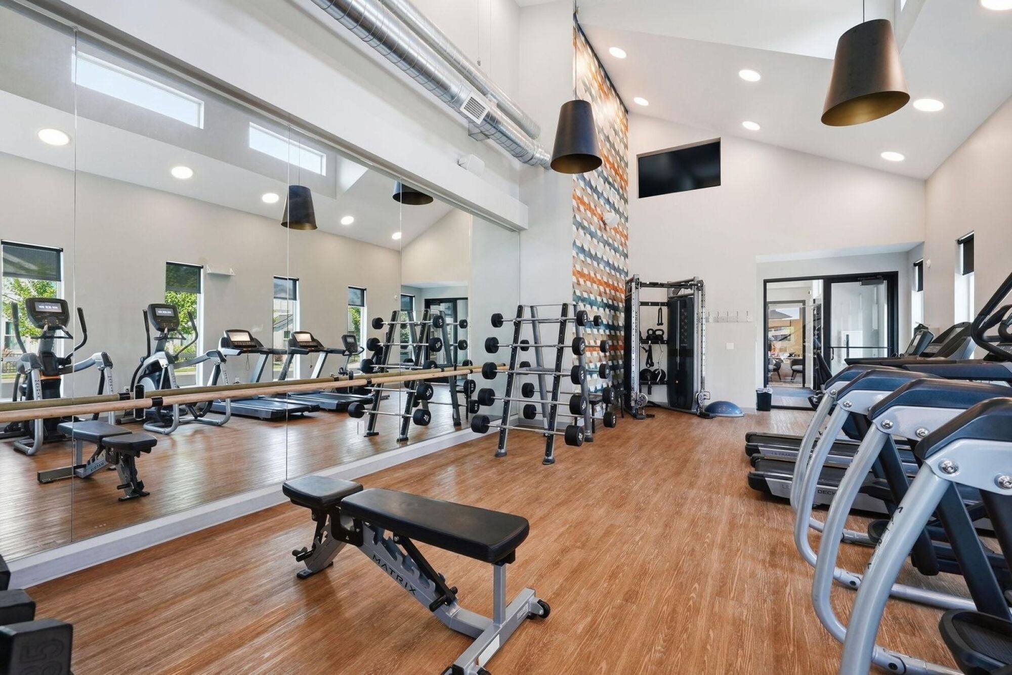 On-site 24-hour fitness center with mirrored walls and strength equipment at Cypress in Redmond, Oregon.