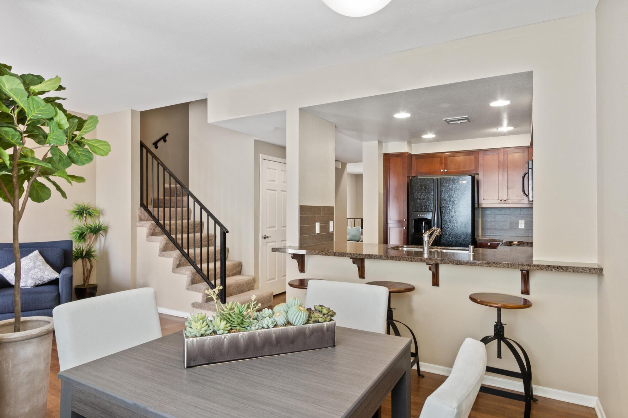 Open dining and kitchen layout in a townhome at Ontario Town Square Townhomes in Ontario, CA, with stairs to the upper level.