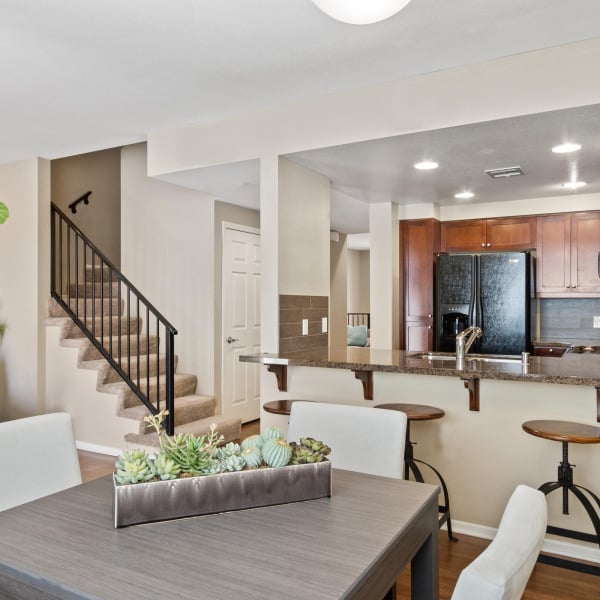Open dining and kitchen layout in a townhome at Ontario Town Square Townhomes in Ontario, CA, with stairs to the upper level.