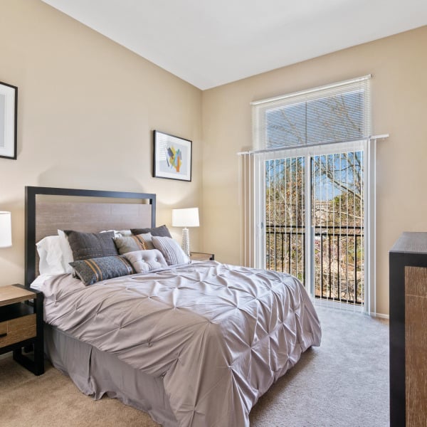 Primary bedroom with private balcony access in a three-bedroom townhome at Ontario Town Square Townhomes in Ontario, CA.