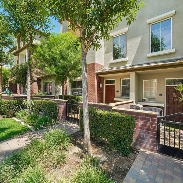Community sidewalk running past gated townhome entries at Ontario Town Square Townhomes in Ontario, California.
