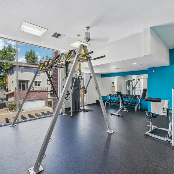 Cable and suspension training station beside a window in the gym at Ontario Town Square Townhomes in Ontario, California.